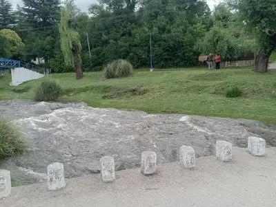 a group of stone pillars in auddle of water at Cabañas Sprinter in Trapiche