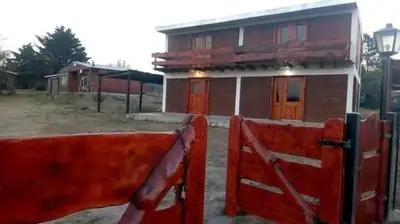 a red fence in front of a house at La Fortaleza in Bialet Massé