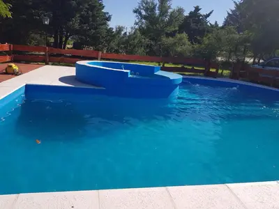 a blue pool with two chairs in the water at La Fortaleza in Bialet Massé