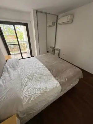 a bed in a bedroom with a large window at Departamento - Complejo Casonas de Manantiales in Cordoba