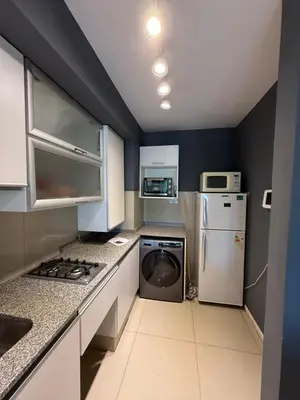 a kitchen with a refrigerator and a washer and dryer at Departamento - Complejo Casonas de Manantiales in Cordoba