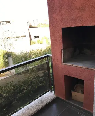 a cat sleeping in a box on a balcony at Departamento - Complejo Casonas de Manantiales in Cordoba