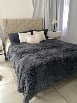 a bed with a gray blanket and pillows on it at Casa de categoría in Santa Rosa de Calamuchita