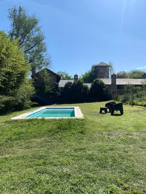 a swimming pool in the middle of a grassy yard at Casa de categoría in Santa Rosa de Calamuchita