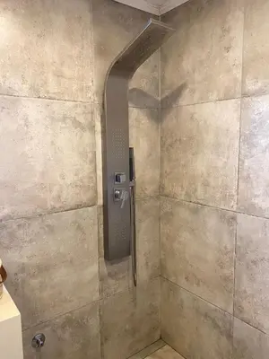 a shower in a bathroom with a stone wall at Casa de categoría in Santa Rosa de Calamuchita