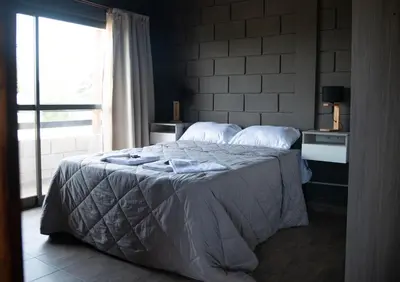 a bedroom with a large bed with a window at En Las Sierras - Departamento de Montaña in Villa Yacanto