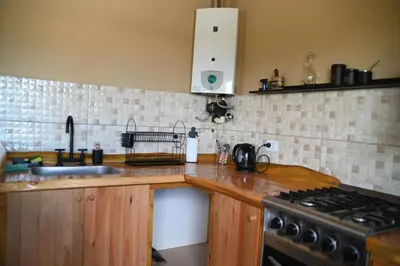 a kitchen with a sink and a stove top oven at En Las Sierras - Departamento de Montaña in Villa Yacanto