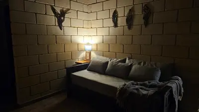 a room with a bed with a lamp and a brick wall at En Las Sierras - Departamento de Montaña in Villa Yacanto