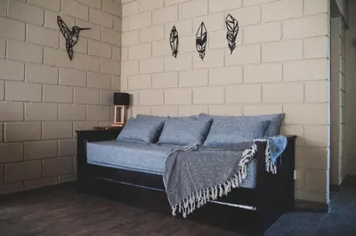 a bedroom with a bed with blue pillows and butterflies on the wall at En Las Sierras - Departamento de Montaña in Villa Yacanto