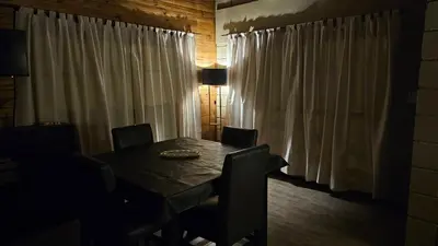 a dining room table and chairs with white curtains at En Las Sierras - Departamento de Montaña in Villa Yacanto