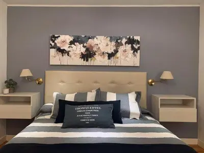 a bedroom with a bed with a painting on the wall at Casa minimalista con vistas a las sierras in Villa Carlos Paz