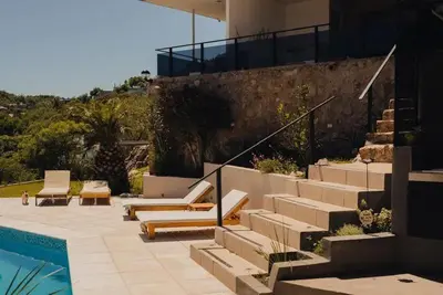 a house with a swimming pool and stairs next to a house at Casa minimalista con vistas a las sierras in Villa Carlos Paz