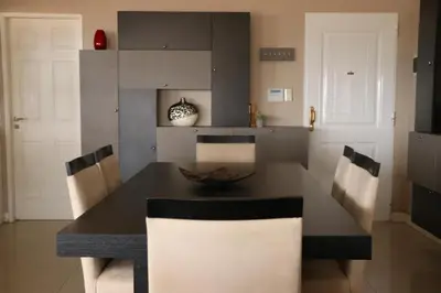 a kitchen with a black table and chairs and a kitchen with white cabinets at Casa minimalista con vistas a las sierras in Villa Carlos Paz