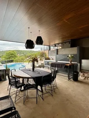 a dining room with a table and chairs and a pool at Casa minimalista con vistas a las sierras in Villa Carlos Paz