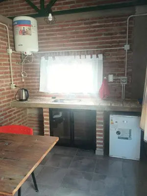 a kitchen with a wooden table and a brick wall at El Parador in Las Bajadas