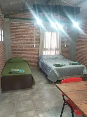 a bedroom with a bed and a table and lights at El Parador in Las Bajadas