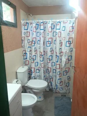 a bathroom with a toilet and a shower curtain at El Parador in Las Bajadas