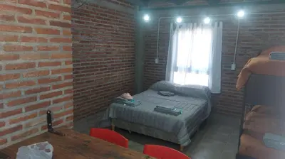 a bedroom with a bed and a brick wall at El Parador in Las Bajadas