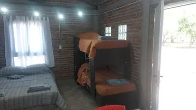 a room with bunk beds in a brick wall at El Parador in Las Bajadas