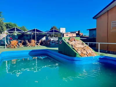 a pool of water with a pile of rocks at KIN Hotel in Villa Carlos Paz