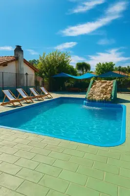 a swimming pool with chairs and a slide at KIN Hotel in Villa Carlos Paz