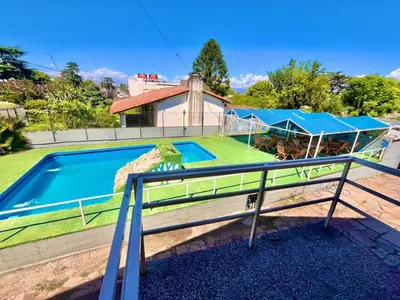 an image of a house with a swimming pool at KIN Hotel in Villa Carlos Paz