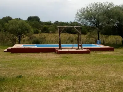an empty playground in a field with trees in the background at Camino de Santidad in Piedras Blancas