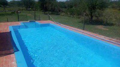 a large blue swimming pool in a yard at Camino de Santidad in Piedras Blancas