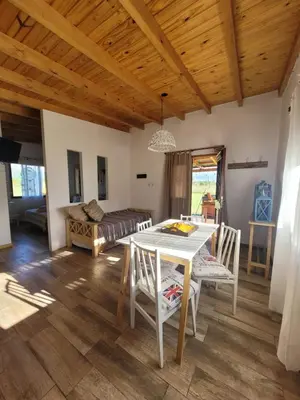 a living room with a table and chairs and a bed at Brisas De Las Sierras in Villa Ciudad Parque