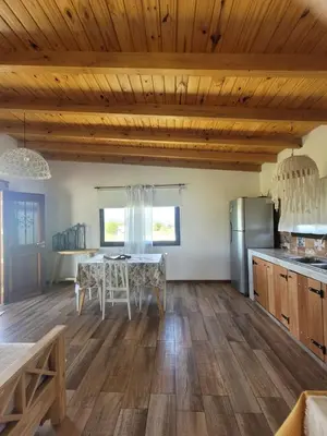 a kitchen with wooden ceilings and a table with chairs at Brisas De Las Sierras in Villa Ciudad Parque
