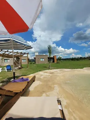 a patio with a table and an umbrella at Brisas De Las Sierras in Villa Ciudad Parque