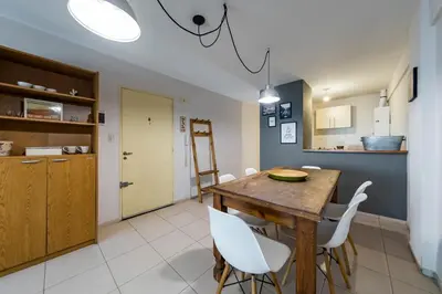 a kitchen and dining room with a wooden table and chairs at Gral Paz con patio privado y asador in Cordoba
