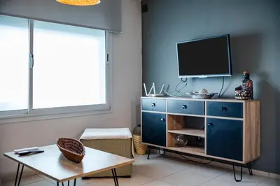 a living room with a blue dresser with a tv on it at Gral Paz con patio privado y asador in Cordoba