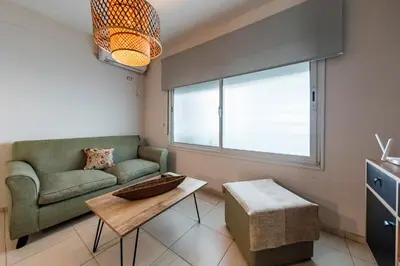 a living room with a couch and a table at Gral Paz con patio privado y asador in Cordoba