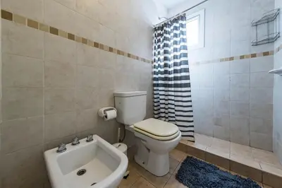 a bathroom with a toilet and a bath tub at Gral Paz con patio privado y asador in Cordoba