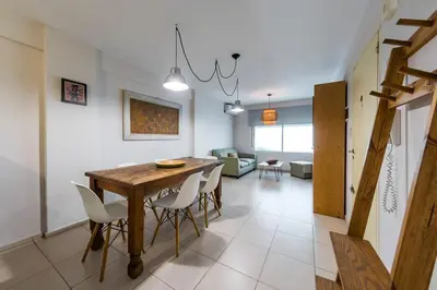 a dining room and living room with a table and chairs at Gral Paz con patio privado y asador in Cordoba