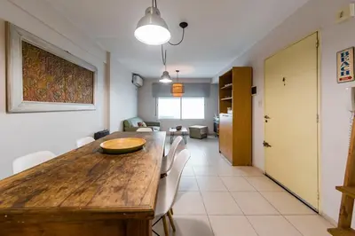 a dining room with a wooden table and chairs at Gral Paz con patio privado y asador in Cordoba