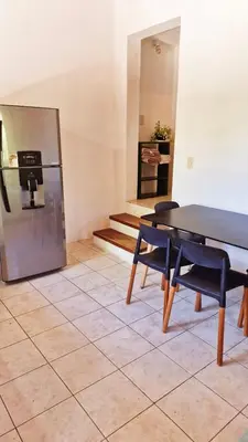 a dining room with a table and a refrigerator at Rohvolk chill aparts in Villa General Belgrano