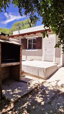 a white garage with a door and a window at Rohvolk chill aparts in Villa General Belgrano