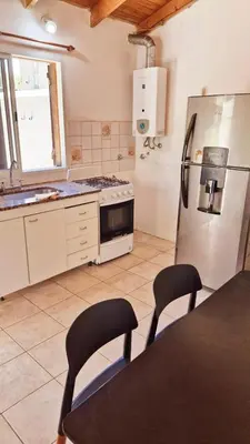 a kitchen with a refrigerator and a table and chairs at Rohvolk chill aparts in Villa General Belgrano