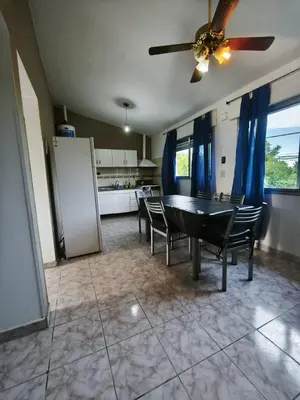 a dining room with a table and chairs and a kitchen at Dpto Villa Carlos Paz max 5 personas