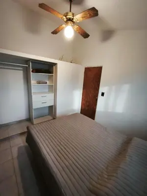 a bedroom with a bed and a ceiling fan at Dpto Villa Carlos Paz max 5 personas