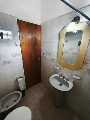 a bathroom with a sink and a toilet and a mirror at Dpto Villa Carlos Paz max 5 personas