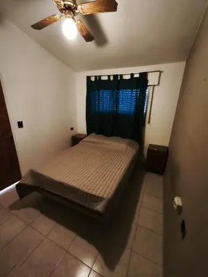 a bedroom with a bed and a ceiling fan at Dpto Villa Carlos Paz max 5 personas