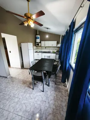 a kitchen with a table and chairs and a ceiling fan at Dpto Villa Carlos Paz max 5 personas
