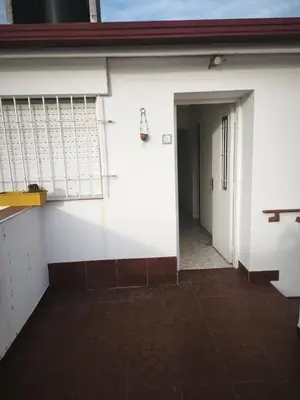 a hallway of a white building with a door and a doorway at Dpto Villa Carlos Paz max 5 personas