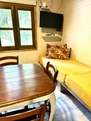 a room with a bed and a table and a tv at La Ribera Aparts in Santa Rosa de Calamuchita