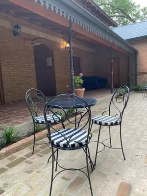 three chairs and a table on a patio at La Ribera Aparts in Santa Rosa de Calamuchita