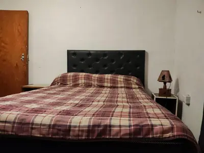a bedroom with a bed with a plaid blanket at Departamentos sandry in Villa Carlos Paz