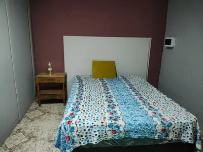 a bedroom with a bed with a quilt on it at Departamentos sandry in Villa Carlos Paz